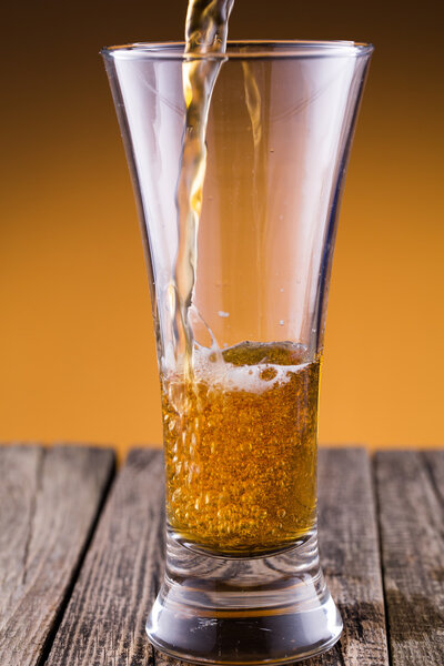 Beer glass in a golden background.