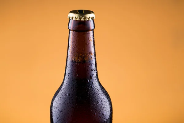 Beer bottle in golden background. — Stock Photo, Image