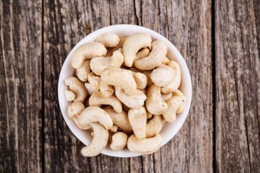 Ahşap arka plan üzerinde bir tabakta kaju fıstığı.