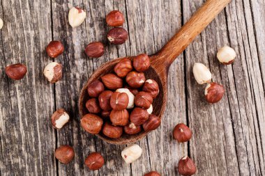 Ahşap arka plan üzerine bir kaşık fındık.