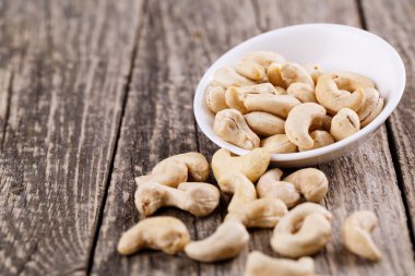 Ahşap arka plan üzerinde bir tabakta kaju fıstığı.