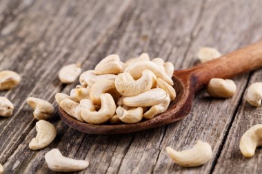 Ahşap arka plan üzerine bir kaşık kaşu fındık.