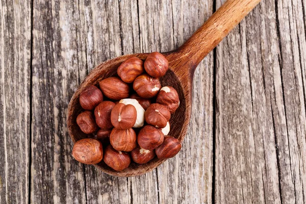 Hazelnuts on a spoon on wooden background. — Stock Photo, Image