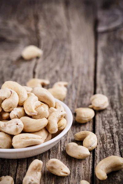 Cashew nuts on a plate on wooden background. — Stock Photo, Image