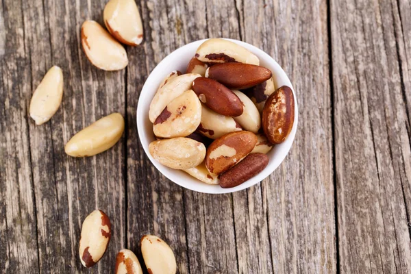 Brazil nuts on a plate on wooden background. — Stock Photo, Image