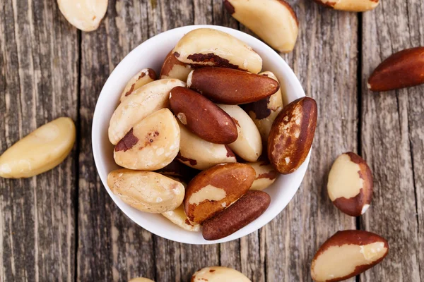 Brazil nuts on a plate on wooden background. — Stock Photo, Image