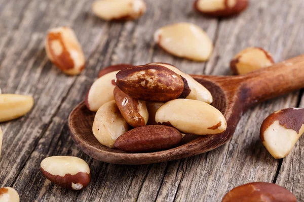 Brazil nuts on a spoon on wooden background. — Stock Photo, Image