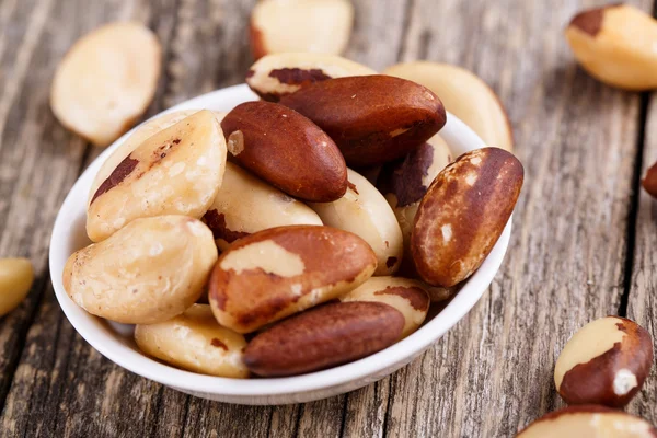 Brazil nuts on a plate on wooden background. — Stock Photo, Image