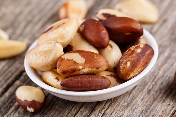 Brazil nuts on a plate on wooden background. — Stock Photo, Image