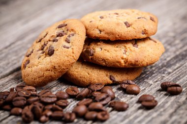 Kurabiye ve kahve çekirdekleri ahşap bir masa üzerinde.