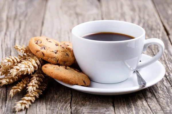 Cup of coffee with cookies and wheat on a table. — Stock Photo, Image