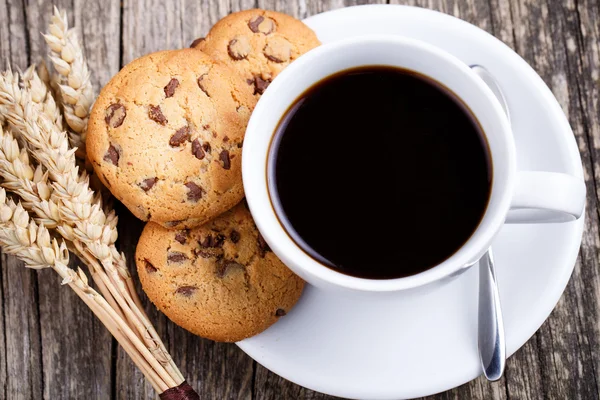 Cup of coffee with cookies and wheat on a table. — Stock Photo, Image