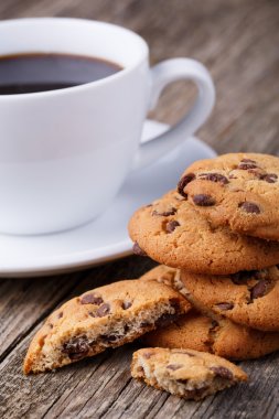 Tahta bir masada bir fincan kahve ve kurabiyeler..