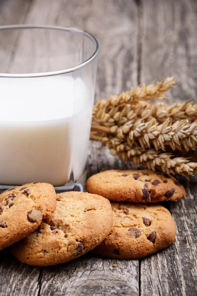 Välsmakande kakor med mjölk på ett träbord. — Stockfoto