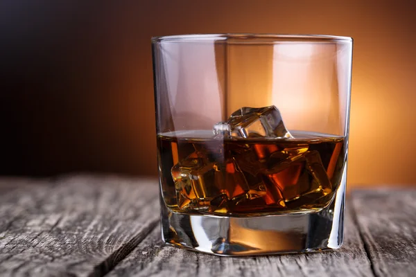 Glas Whiskey und Eis auf einem Holztisch. — Stockfoto