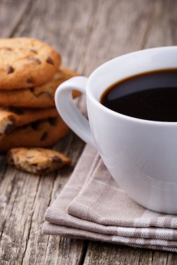 Tahta bir masada bir fincan kahve ve kurabiyeler..