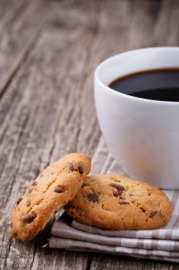 Tahta bir masada bir fincan kahve ve kurabiyeler..