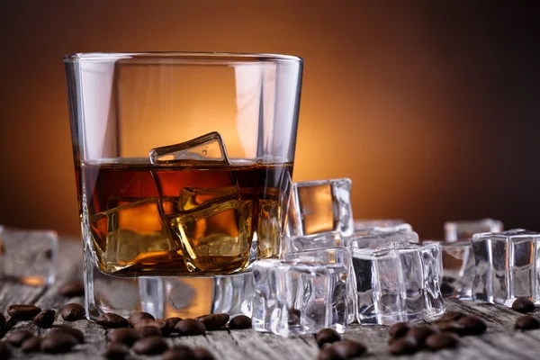 Vaso de whisky con hielo y granos de café . —  Fotos de Stock