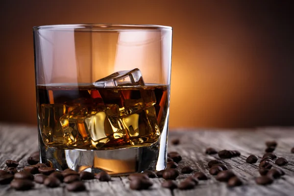Vaso de whisky con hielo y granos de café . — Foto de Stock
