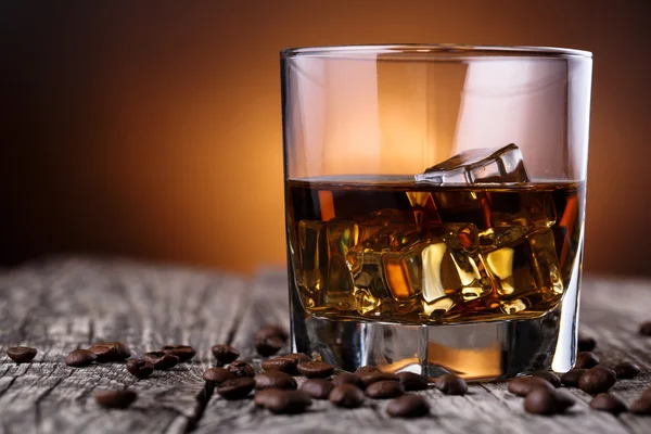 Vaso de whisky con hielo y granos de café . — Foto de Stock
