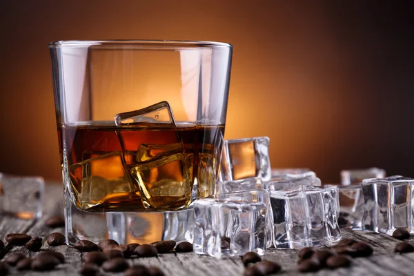 Vaso de whisky con hielo y granos de café . — Foto de Stock