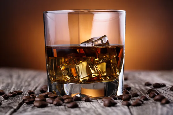 Glas whiskey med is och kaffebönor. — Stockfoto