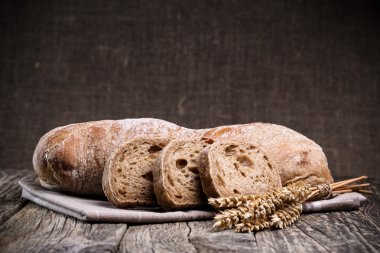 Ahşap arka plan üzerinde buğday ile lezzetli ekmek.
