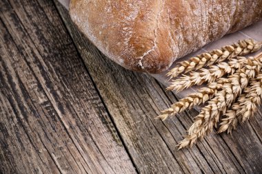 Ahşap arka plan üzerinde buğday ile lezzetli ekmek.
