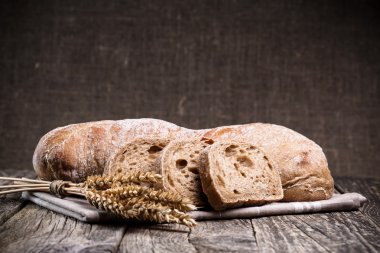 Ahşap arka plan üzerinde buğday ile lezzetli ekmek.