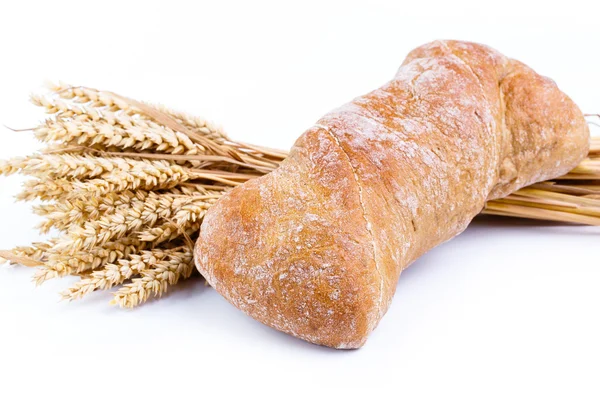 Leckeres Brot mit Weizen auf weißem Hintergrund. — Stockfoto