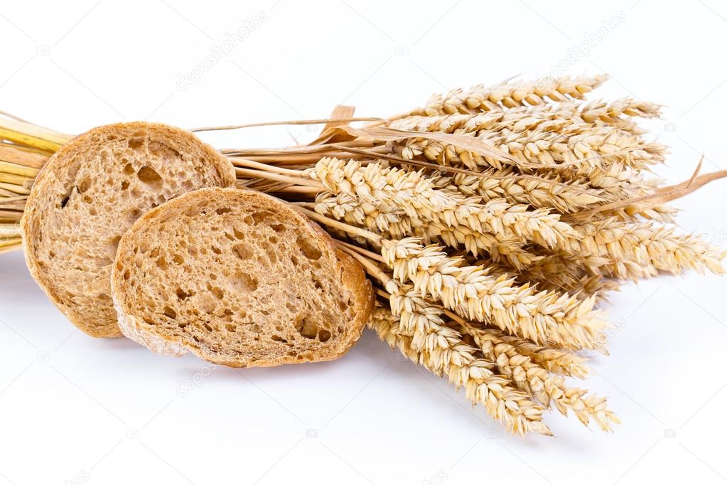 Tasty bread with wheat on a white background.