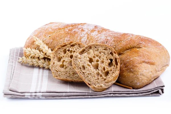 Välsmakande bröd med vete på vit bakgrund. — Stockfoto