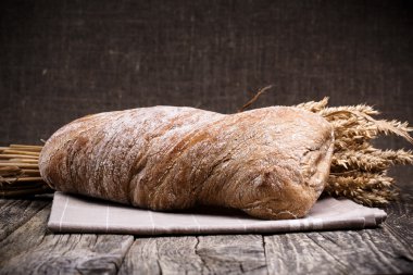 Ahşap arka plan üzerinde buğday ile lezzetli ekmek.