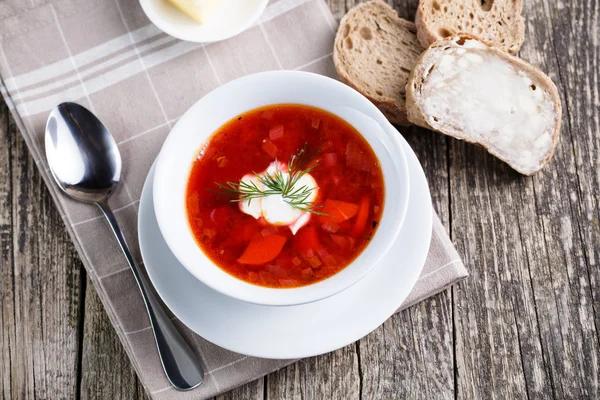 Lekkere soep met brood op een houten achtergrond. — Stockfoto