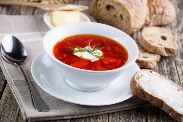 Lekkere soep met brood op een houten achtergrond. — Stockfoto