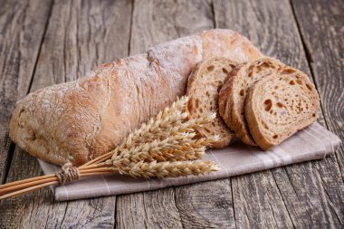 Ahşap arka plan üzerinde buğday ile lezzetli ekmek.