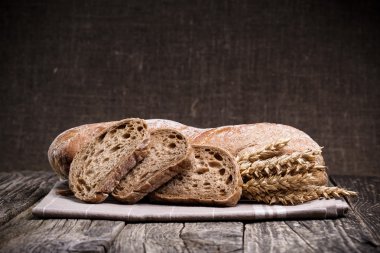 Ahşap arka plan üzerinde buğday ile lezzetli ekmek.