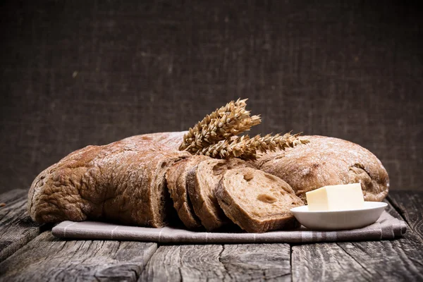 Pain savoureux avec du blé sur fond de bois . — Photo