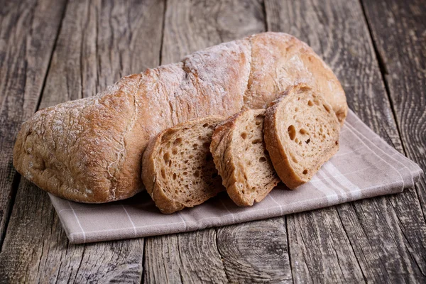 Tasty bread with wheat on wooden background. — Stock Photo, Image