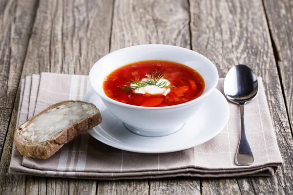 Lekkere soep met brood op een houten achtergrond. — Stockfoto
