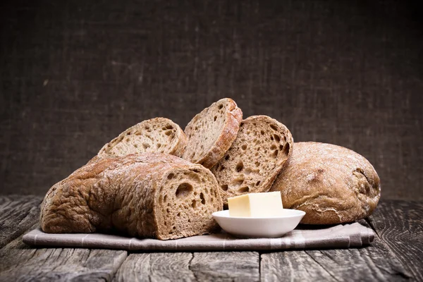 Pain savoureux avec du blé sur fond de bois . — Photo