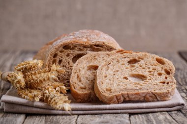 Ahşap arka plan üzerinde buğday ile lezzetli ekmek.