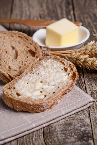 Tasty bread with wheat on wooden background. — Stock Photo, Image