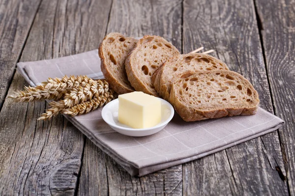 Sabroso pan con trigo sobre fondo de madera . — Foto de Stock