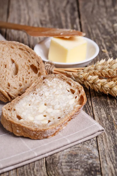 Tasty bread with wheat on wooden background. — Stock Photo, Image