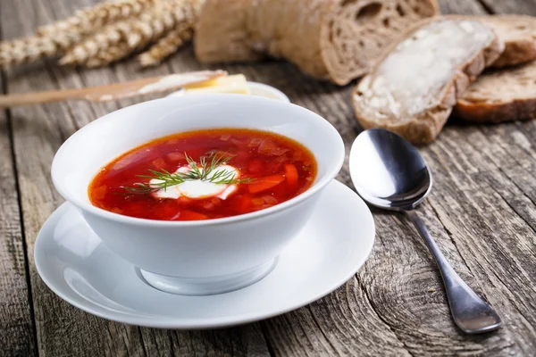 Tasty soup with bread on a wooden background. — Stock Photo, Image