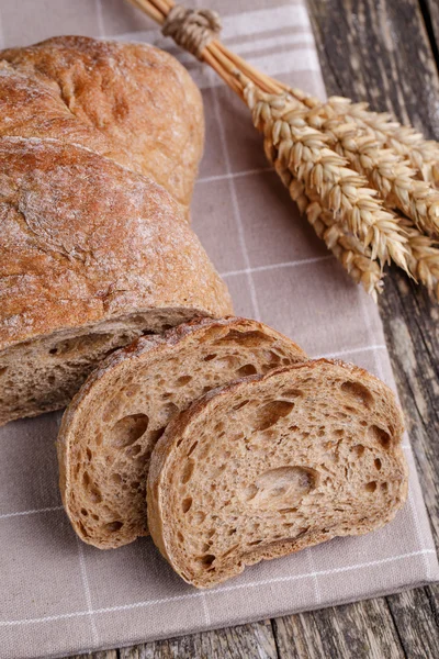 Sabroso pan con trigo sobre fondo de madera . — Foto de Stock