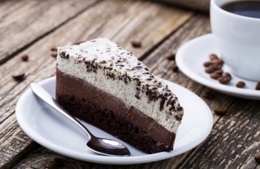 Çikolata tatlı kahve fincanı ve kahve çekirdekleri ahşap bac üzerinde