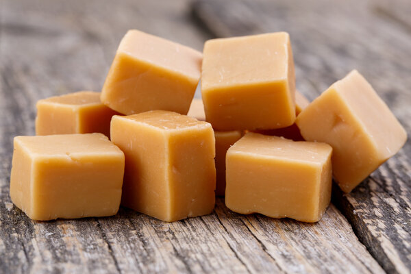 Tasty toffees on wooden background.