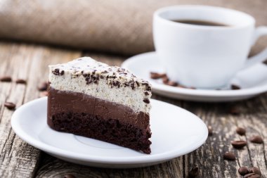 Çikolata tatlı kahve fincanı ve kahve çekirdekleri ahşap bac üzerinde